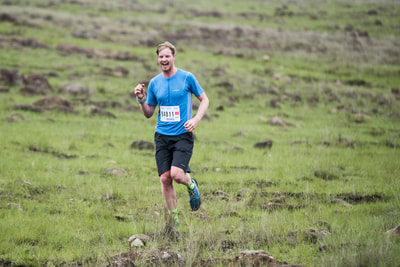 Russel Canning all smiles and fist pimps as he recognises the camera, clearly loving his trail run - (c) Andrew Mc Fadden / BOOGS Photography